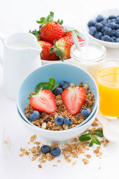 healthy breakfast - granola, fresh berries, orange juice and mil