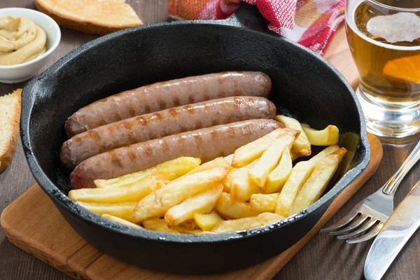 Lunch with grilled sausages, French fries, toast and beer, close — Stock Photo, Image