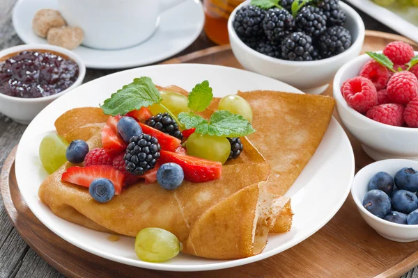 Breakfast - crepes with fresh berries and honey, coffee on woode — Stock Photo, Image