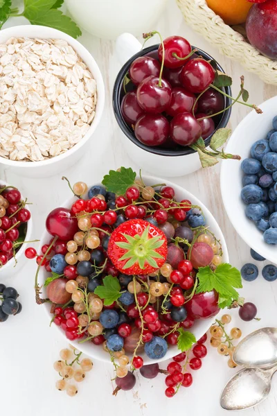 Oogst van verse bessen en vruchten op witte houten tafel, top v — Stockfoto