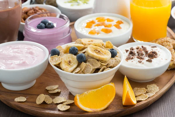 Generös frukostbuffé med flingor, yoghurt och frukt på trä — Stockfoto