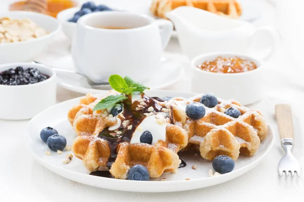 Gofres con arándanos frescos, crema y salsa de chocolate en una p — Foto de Stock