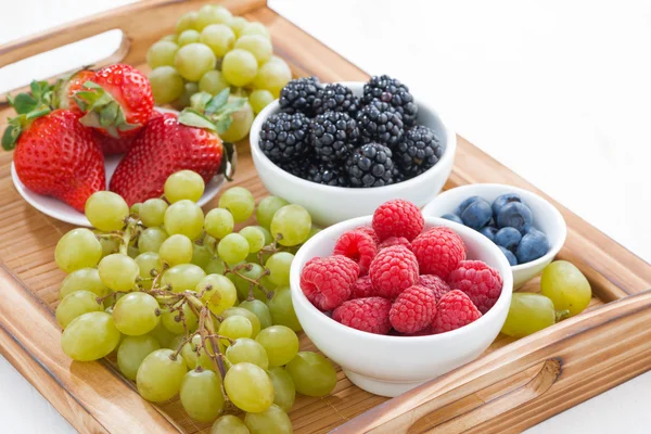 Bandeja de madera con bayas frescas y uvas —  Fotos de Stock