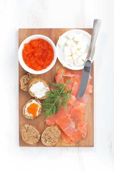 Salted salmon, red caviar, toast and butter on a wooden board, t — Stock Photo, Image