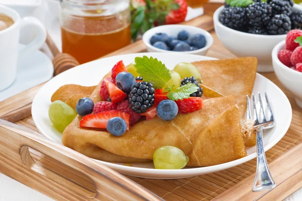 Crepes with fresh berries and honey on a plate — Stock Photo, Image