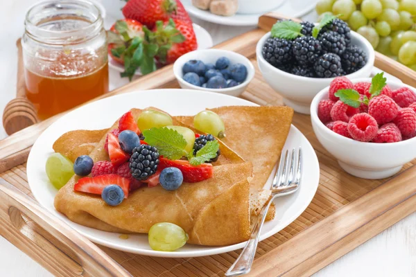 Heerlijk ontbijt - pannenkoeken met verse bessen en honing op woo — Stockfoto