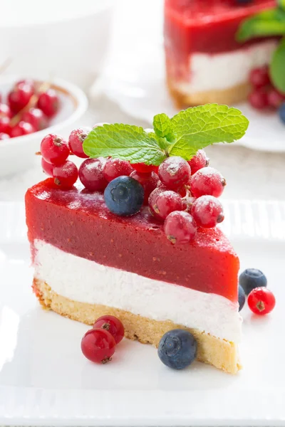 Piece of delicious cheesecake with berry jelly on a plate, verti — Stock Photo, Image