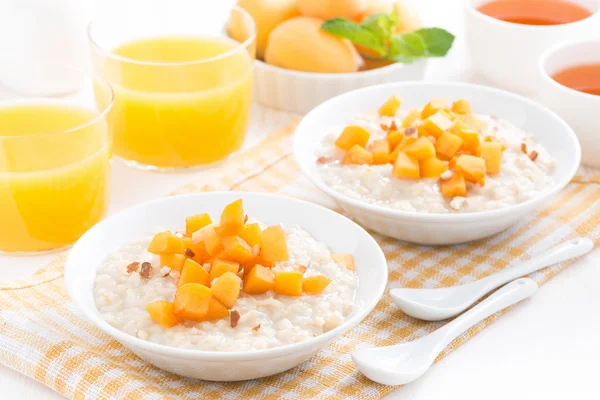 Овсянка со свежими абрикосами, апельсиновый сок и чай — стоковое фото