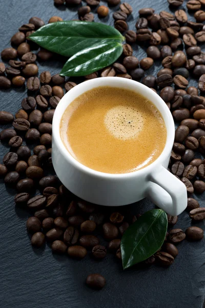 Чашка эспрессо на фоне кофейных зерен, вид сверху — стоковое фото