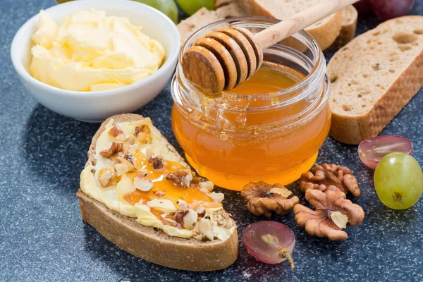 Honey, bread with butter and grape, horizontal, top view — Stock Photo, Image