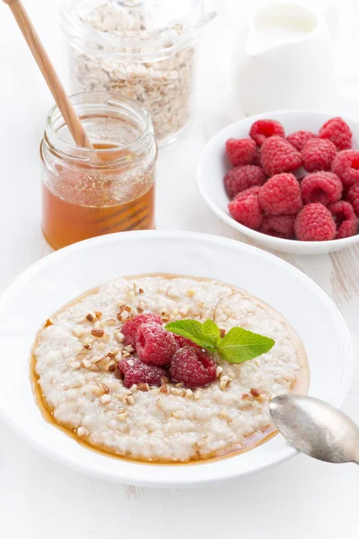 Oatmeal with raspberries and honey, vertical — Stock Photo, Image