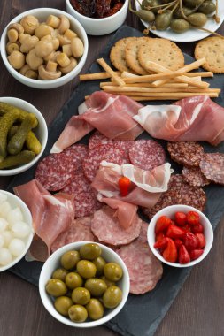 Çeşitli Şarküteri et aperatifler, sosis ve bir kara tahta üzerinde turşu