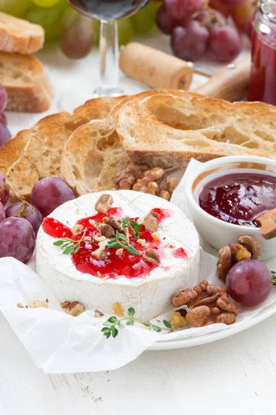 Закуски для вина - камамбер с ягодным джемом, тостами и фруктами — стоковое фото