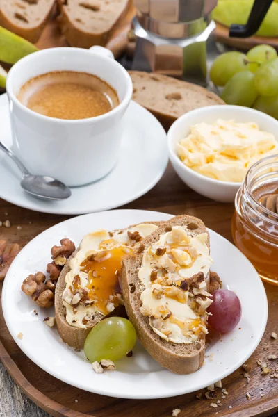 Bread with butter, honey, nuts and grapes for breakfast — Stock Photo, Image