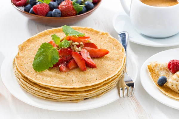 Crepes with fresh strawberry, jams and honey on white table — Stock Photo, Image