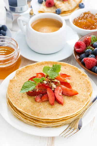 Crepes with strawberries and honey on white wooden background — Stock Photo, Image