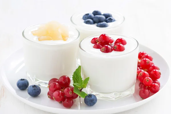 Natural yogurt with fresh berries in glass jars, close-up — Stock Photo, Image