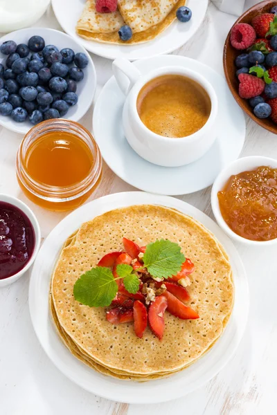 Crepes with strawberry, jams and honey on white background — Stock Photo, Image