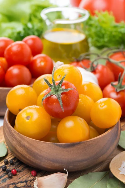 Yellow and red cherry tomatoes in wooden bowls, close-up — Stock Photo, Image