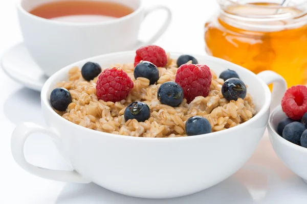 Kahvaltı - taze meyveler ve bal, siyah çay ile yulaf lapası — Stok fotoğraf
