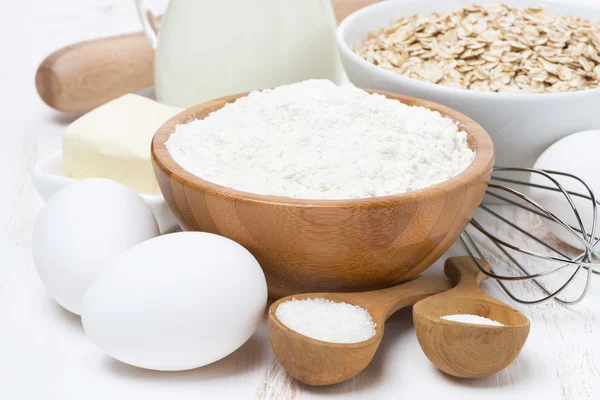 Milk, cereal and ingredients for baking on wooden table — Stock Photo, Image