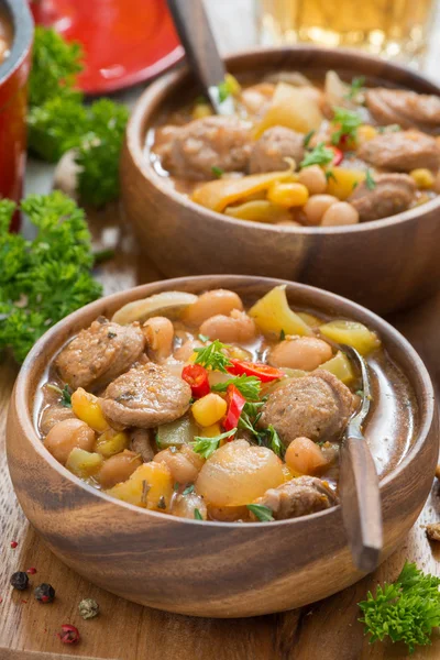 Delicious vegetable stew with sausages in a wooden bowl — Stock Photo, Image