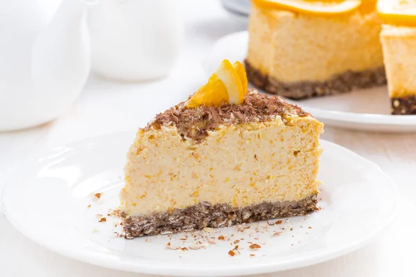 Stuk van Oranje cheesecake op een witte plaat — Stockfoto