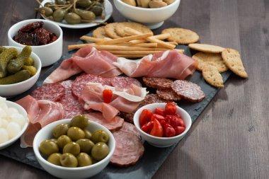 Şarküteri et aperatifler, sosis ve koyu ahşap bir masa üzerinde turşu