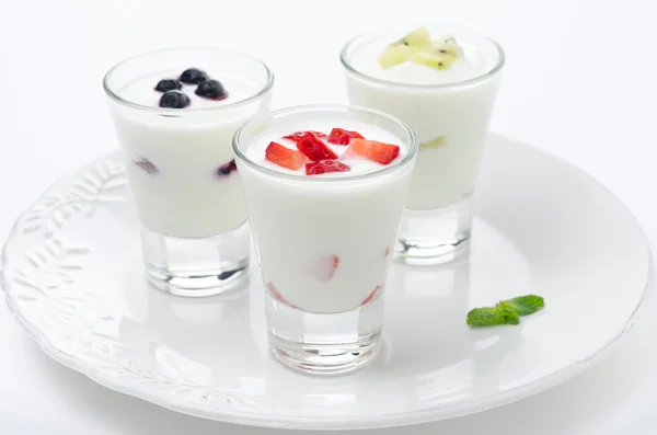 Yatay bir cam kabı meyve ile üç yoğurt — Stok fotoğraf
