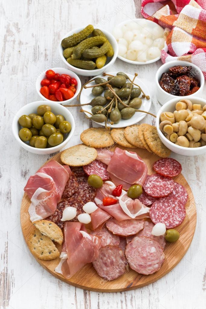 Assorted meat snacks, sausages and pickles, top view, vertical