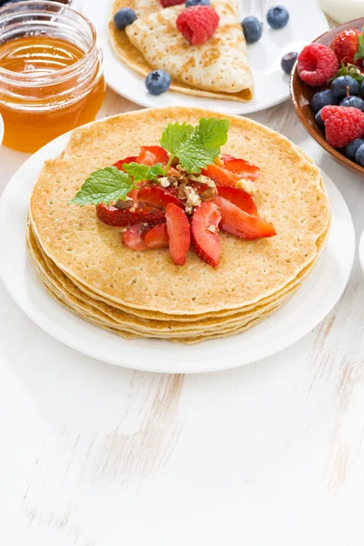 Delicious crepes with strawberries and honey on white — Stock Photo, Image