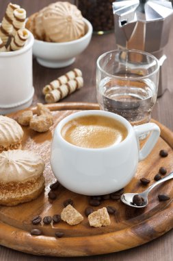 taze espresso, kurabiye ve bir bardak su ahşap tepsi