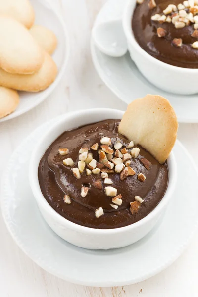 Chocolate mousse with biscuits and nuts in white cups, vertical — Stock Photo, Image