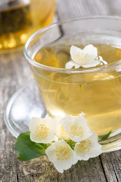 Šálek zeleného čaje s jasmine na dřevěné pozadí — Stock fotografie