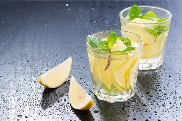 Limonada fresca con menta en vasos sobre fondo oscuro —  Fotos de Stock