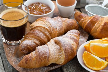 breakfast with fresh croissants on wooden table