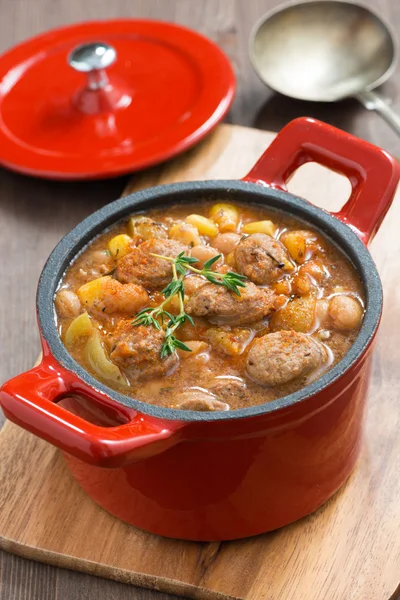 Delicious vegetable stew with sausages in a red pan — Stock Photo, Image