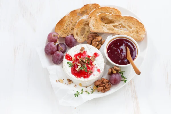 Camembert with berry jam and toast on a white wooden background — Stock Photo, Image