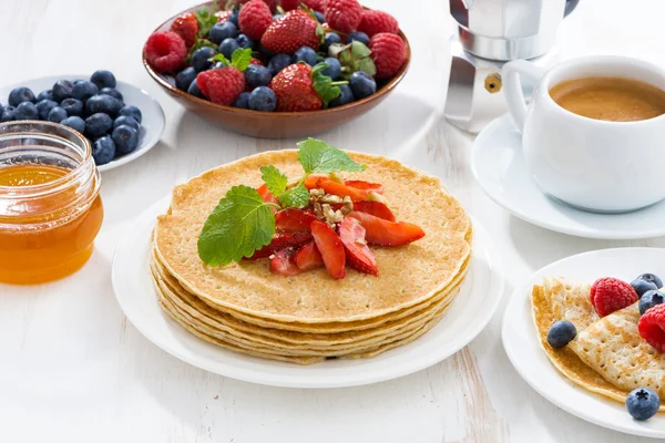 Crepes with strawberry, jams and honey on white table — Stock Photo, Image