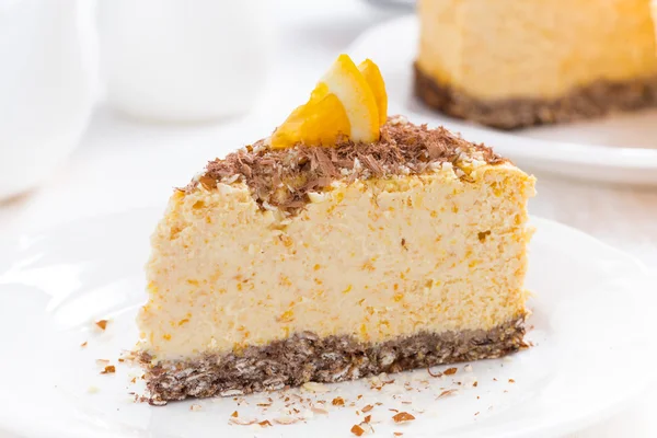 Stuk van Oranje cheesecake op een plaat, close-up — Stockfoto
