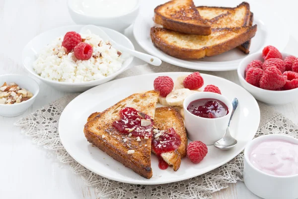 Sweet breakfast - crispy toasts with raspberries, banana and jam — Stock Photo, Image