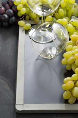 boş bardak şarap ve üzüm dikey bir kara tahta üzerinde