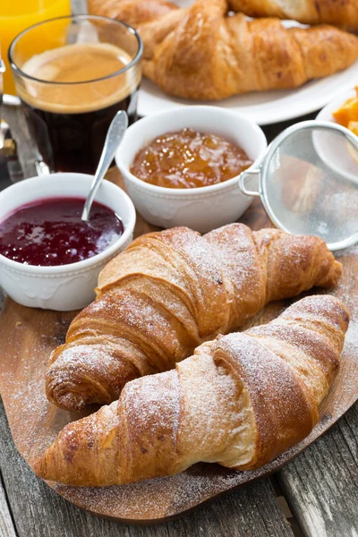 Delicious breakfast with fresh croissants on wooden table — Stock Photo, Image