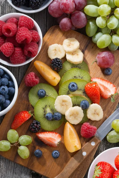 Ingredients for fruit salad on wooden board, top view vertical — Stock Photo, Image