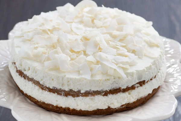 Chocolate cake with coconut cream on a dark background, close-up Stock Picture