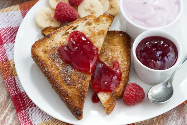 Sweet toasts with fresh raspberry, jam and yoghurt for breakfast — Stock Photo, Image