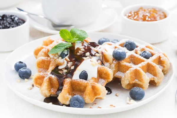 Waffles com mirtilos, nata e molho de chocolate em um prato — Fotografia de Stock