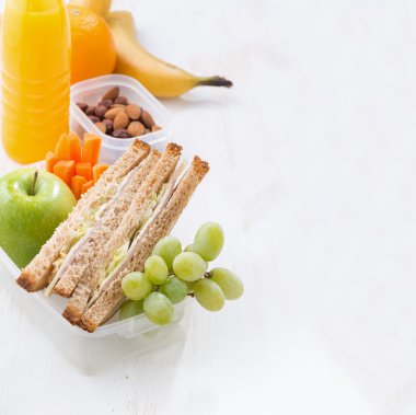 school lunch with sandwich on white wooden table