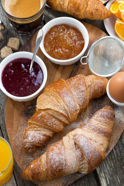 Läcker frukost med färska croissanter på träbord — Stockfoto