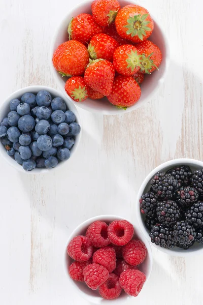 Fresh berries in a  bowl on white wooden background, top view — ストック写真